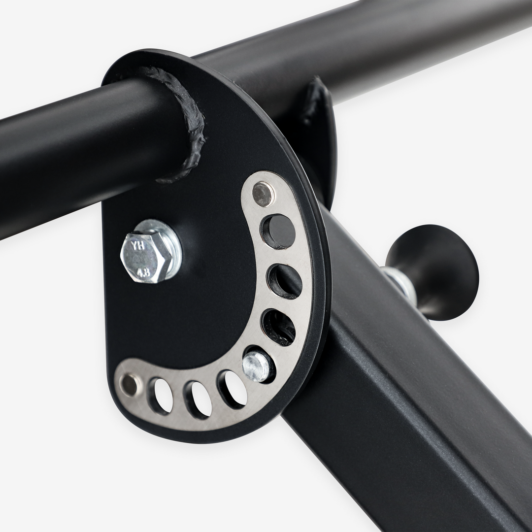 Close-up of a black metal bracket with circular cutouts on a white background