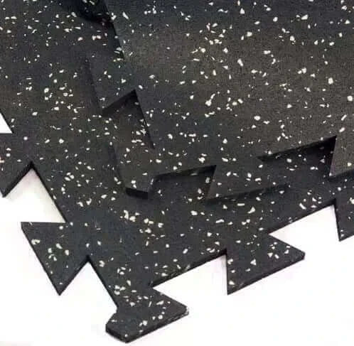 Interlocking rubber mat with textured surface, ideal for gym equipment like treadmills and weights.